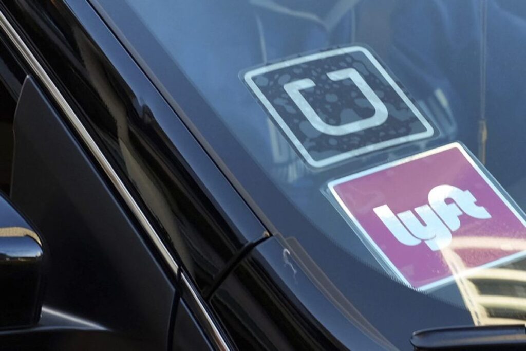 Uber and Lyft stickers on car windshield.